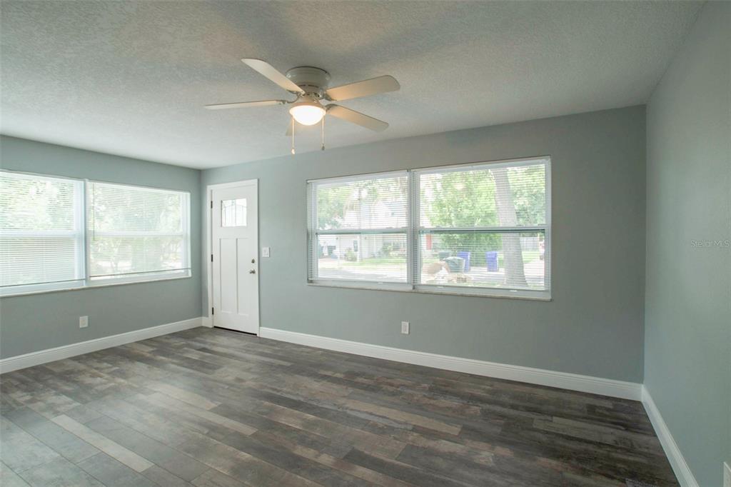 715 Bay Street Dunedin, FL 34698 - Photo 10 of 19 an empty room with wooden floor windows and fan