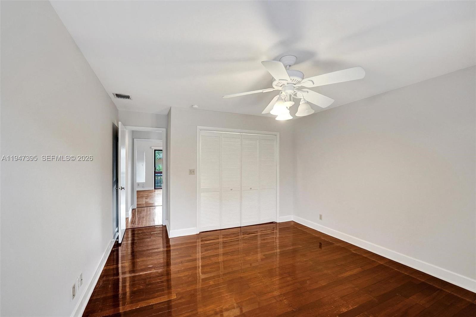 2990 Oaktree Lane, Unit 338 Hollywood, FL 33021 - Photo 15 of 24 wooden floor in an empty room with a chandelier fan