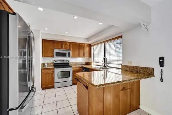a view of an empty room and window a kitchen area