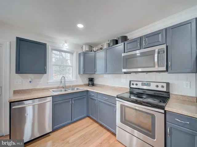 a kitchen with stainless steel appliances granite countertop a sink stove and microwave