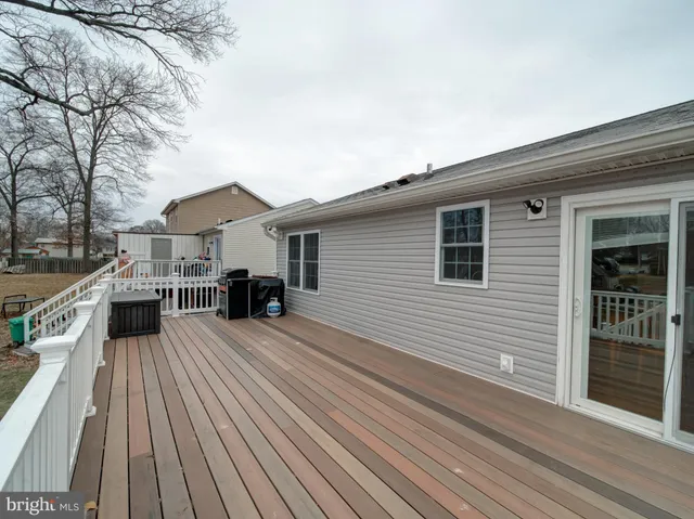 a view of a house with a barbeque and wooden stairs