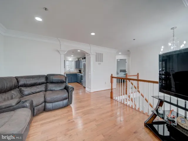 a living room with furniture a flat screen tv and a table