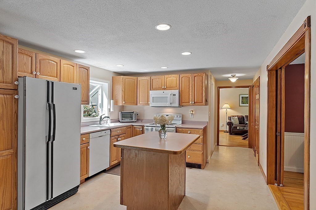69 Hill Road Groton, MA 01450 - Photo 25 of 42 a kitchen with refrigerator a sink and cabinets
