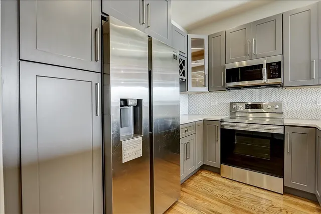 a kitchen with stainless steel appliances granite countertop a refrigerator a stove and a microwave