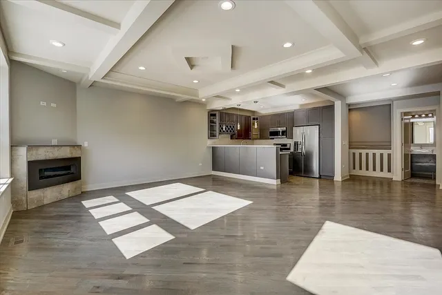 an entryway with kitchen view and living room with a fireplace