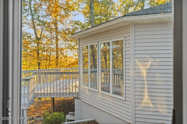 a view of a hallway with wooden floor and a living room