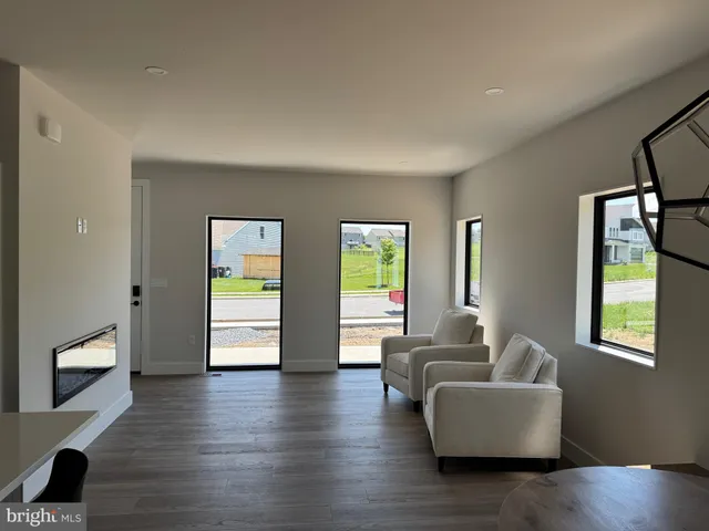 a living room with furniture and two windows