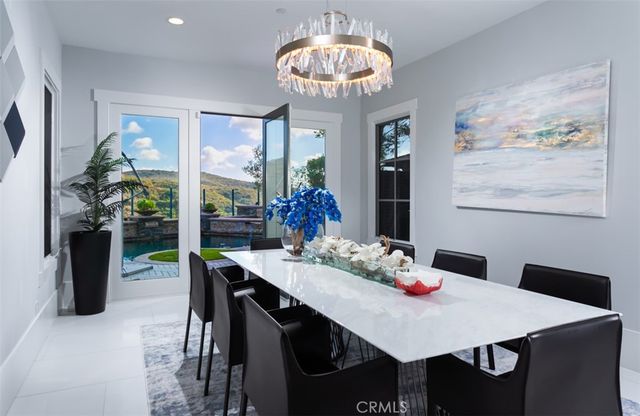 a view of a dining room with furniture large window wooden floor and chandelier