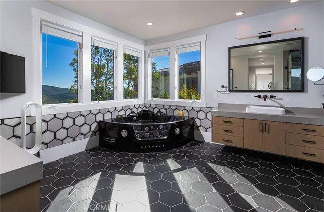 a bathroom with a bathtub sink and mirror