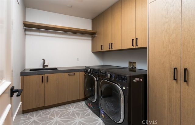 a utility room with sink dryer and washer