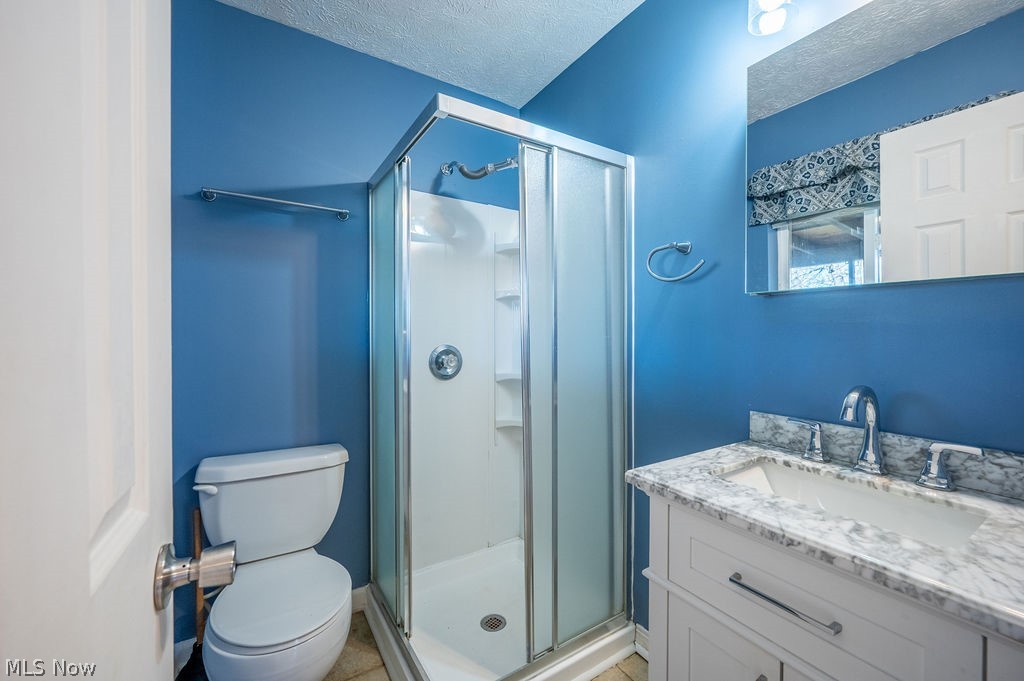 3601 River Road Vienna, WV 26105 - Photo 17 of 40 Bathroom featuring a stall shower, vanity, and a textured ceiling