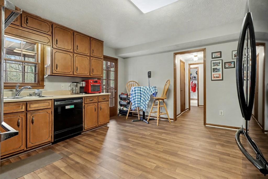 9133 Snipe Lane Jonesboro, GA 30236 - Photo 15 of 36 a kitchen with stainless steel appliances granite countertop a refrigerator a sink dishwasher a stove top oven a dining table and chairs with wooden floor