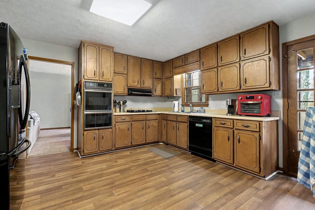 9133 Snipe Lane Jonesboro, GA 30236 - Photo 16 of 36 a kitchen with stainless steel appliances a sink cabinets and wooden floor