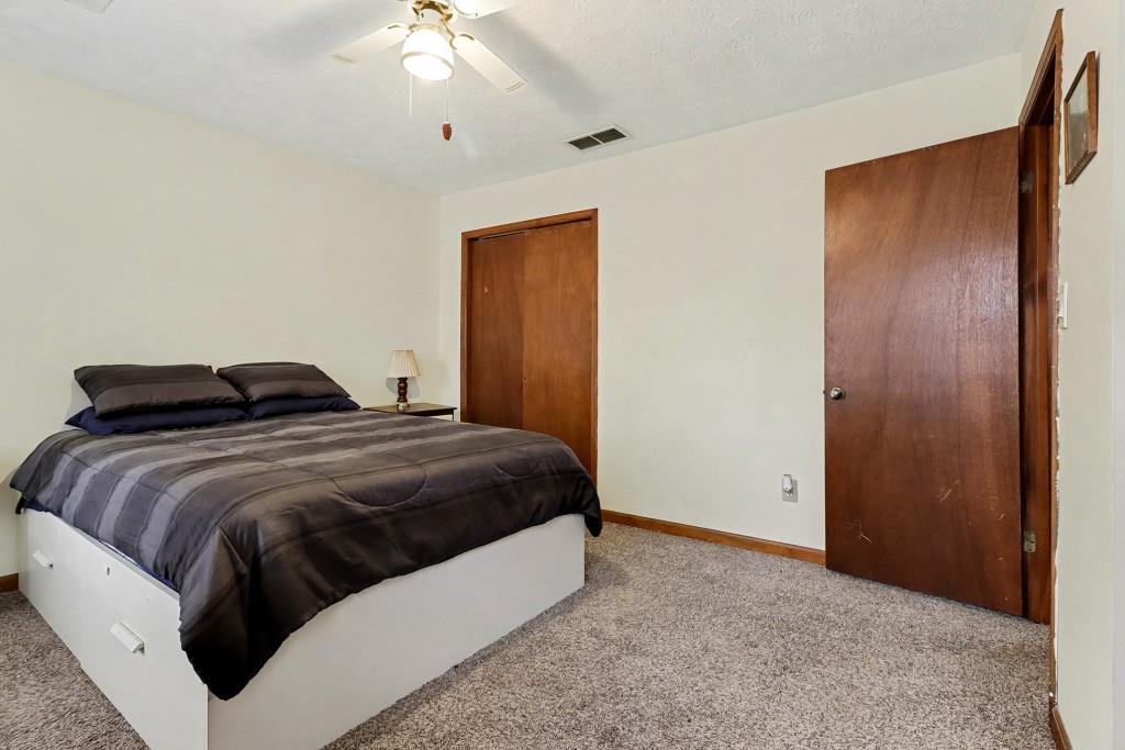 9133 Snipe Lane Jonesboro, GA 30236 - Photo 25 of 36 a bedroom with a bed and a chandelier