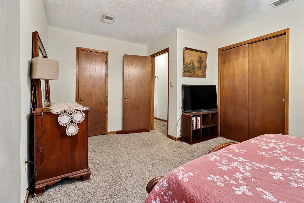 9133 Snipe Lane Jonesboro, GA 30236 - Photo 29 of 36 a bedroom with a bed and a flat tv screen on dresser
