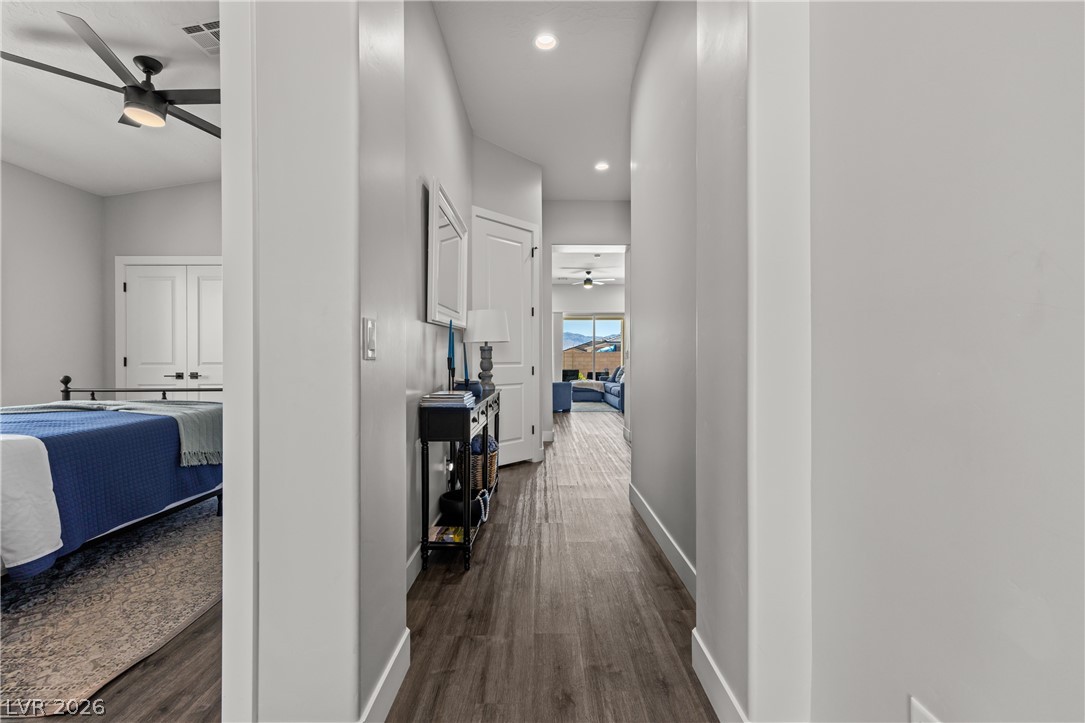 1436 Manassas Ridge Mesquite, NV 89027 - Photo 11 of 77 A well-lit corridor with rich wood-look flooring connects various rooms, offering glimpses of mountain views.