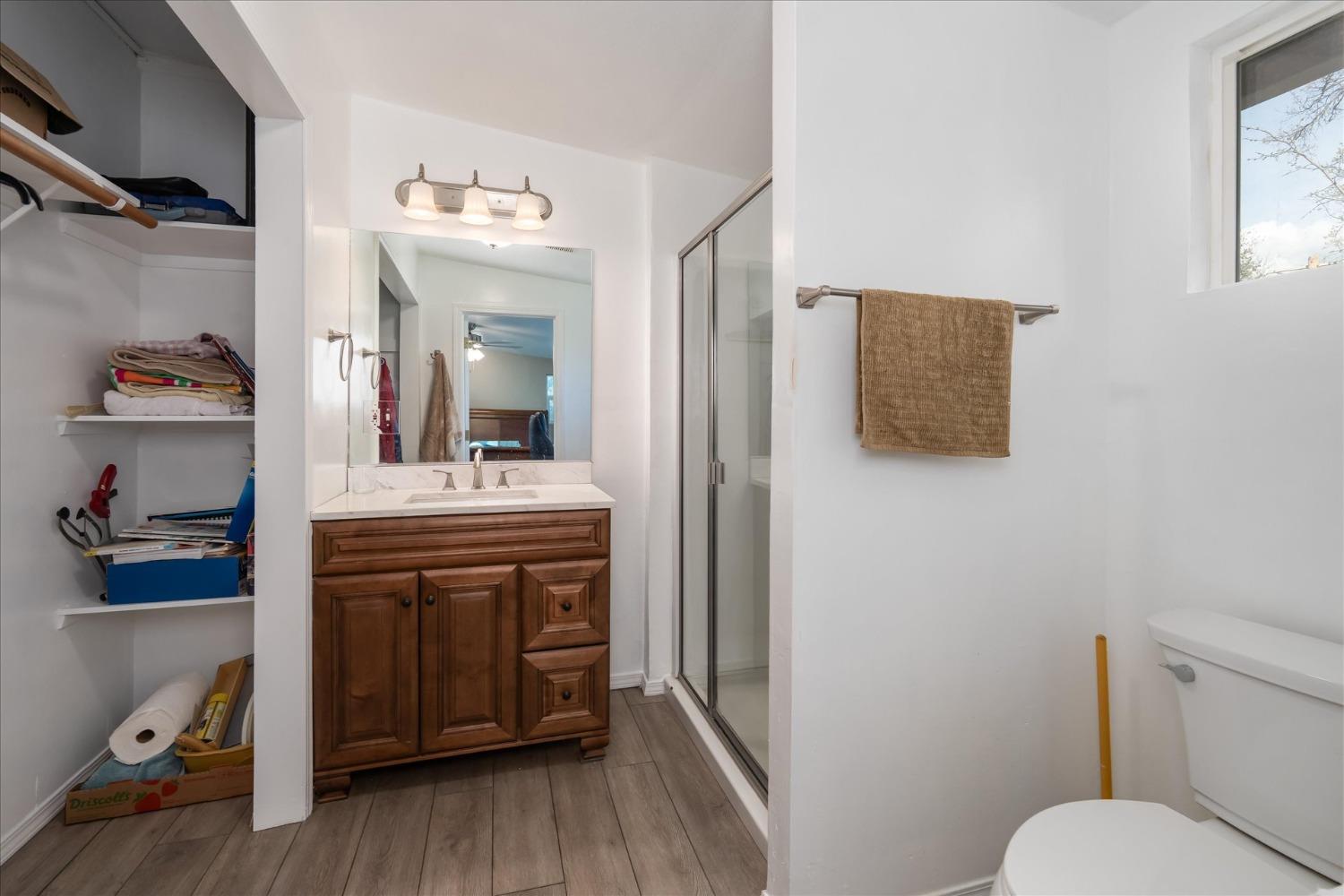 48994 Manzanita Road Oakhurst, CA 93644 - Photo 18 of 43 a en suite bathroom with a toilet sink and mirror