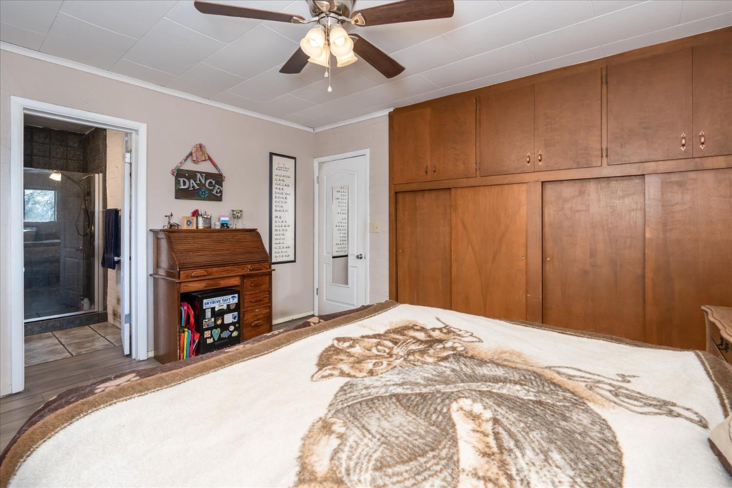 48994 Manzanita Road Oakhurst, CA 93644 - Photo 20 of 43 a bedroom with a bed and a chandelier