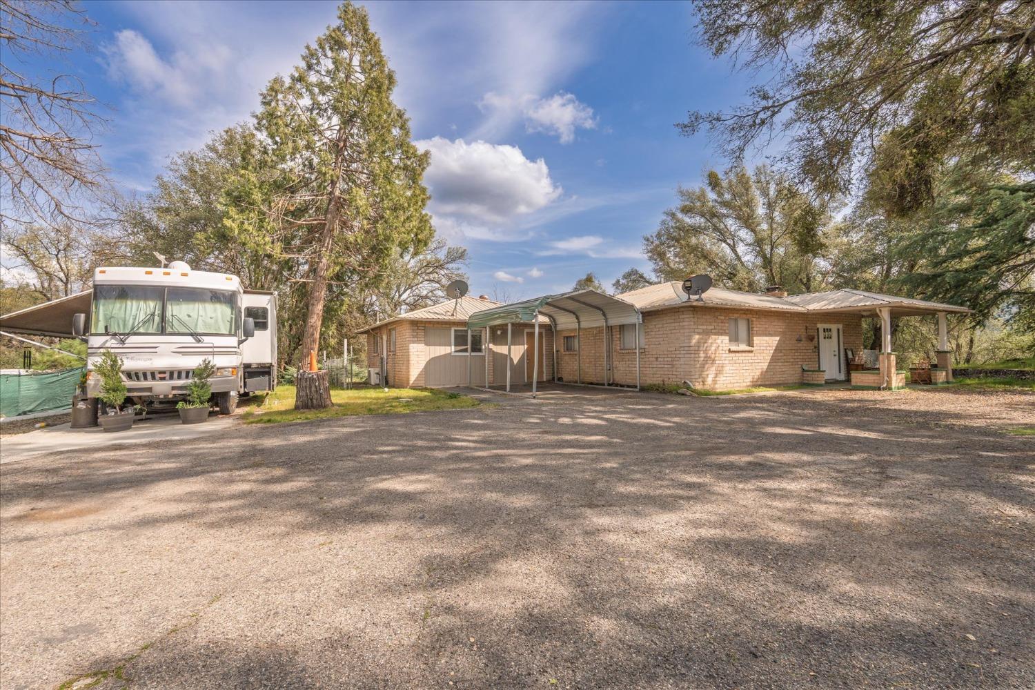 48994 Manzanita Road Oakhurst, CA 93644 - Photo 2 of 43 a front view of a house with a yard and garage