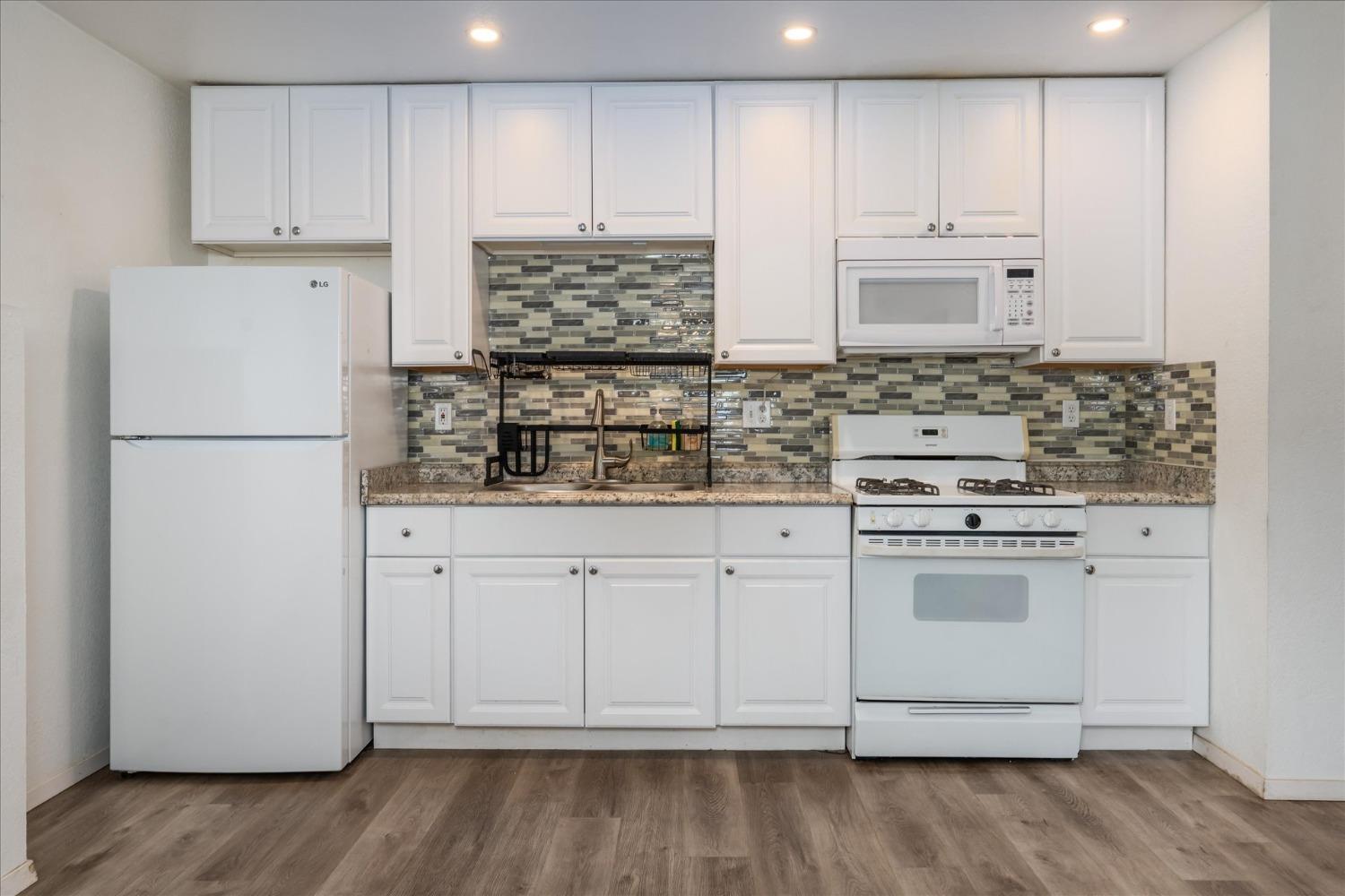 48994 Manzanita Road Oakhurst, CA 93644 - Photo 28 of 43 a kitchen with white cabinets and white appliances