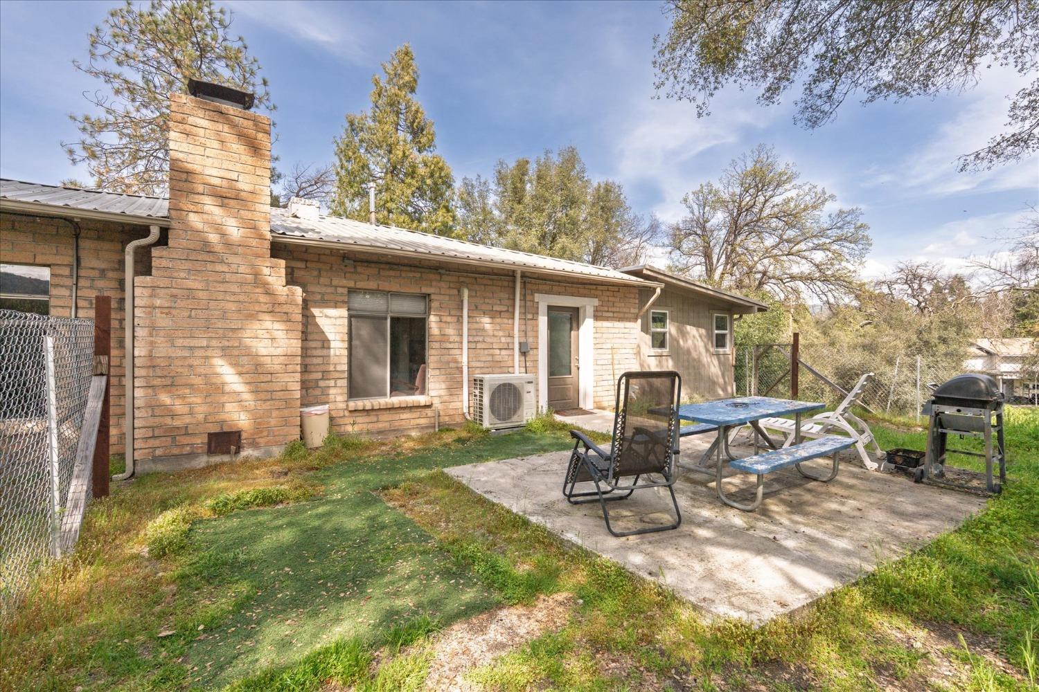 48994 Manzanita Road Oakhurst, CA 93644 - Photo 36 of 43 a view of a house with backyard sitting area and garden