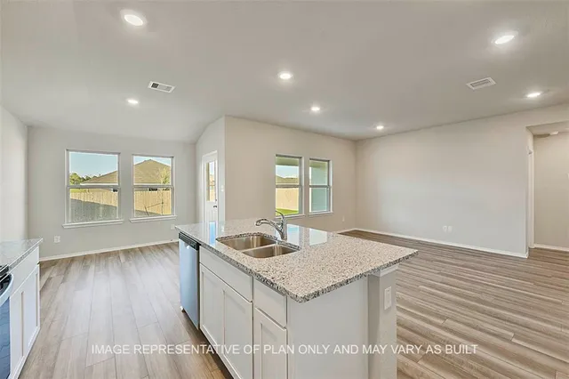 a kitchen with granite countertop a sink and wooden floor