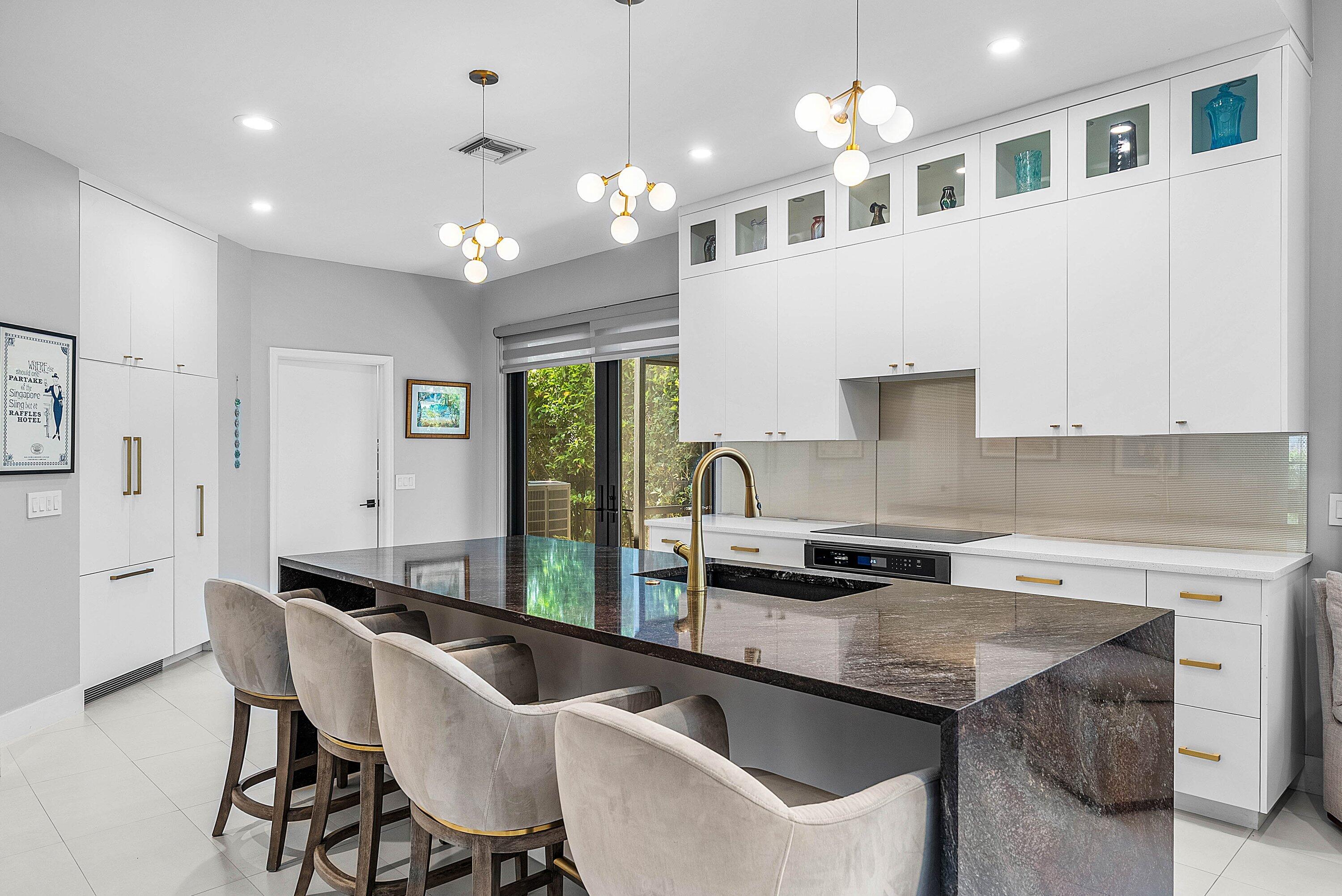 2413 Northwest 64th Street Boca Raton, FL 33496 - Photo 8 of 45 a kitchen with granite countertop a sink a counter top space cabinets and stainless steel appliances