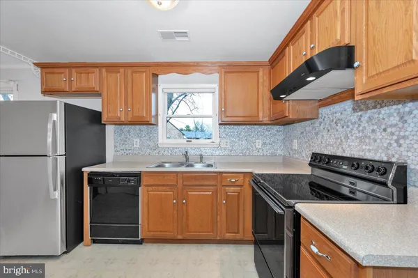 a kitchen with a sink a stove and a refrigerator