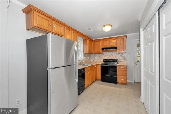 a kitchen with stainless steel appliances white cabinets and a refrigerator