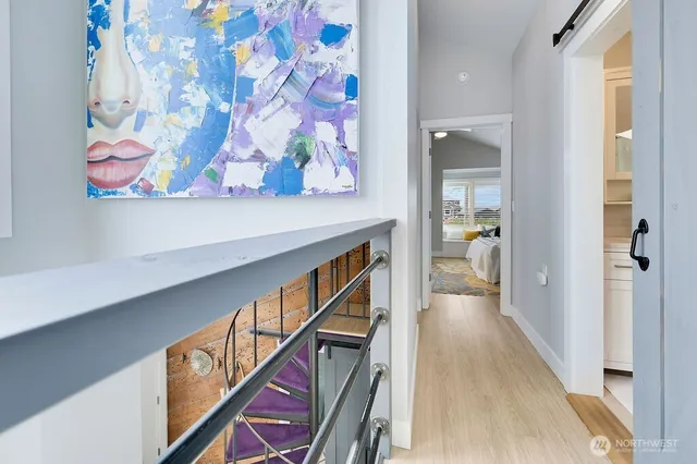 a view of a hallway with wooden floor and stairs