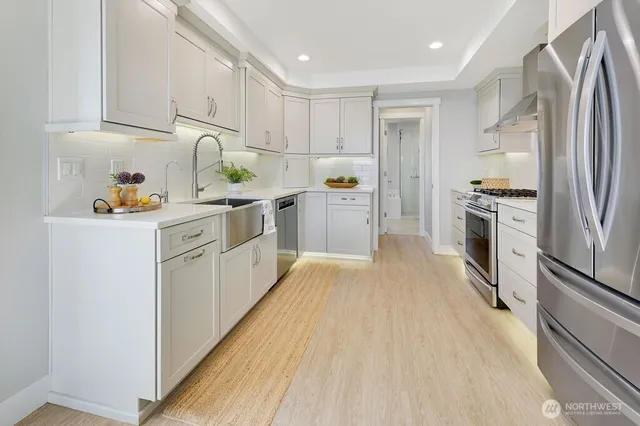 a kitchen with a sink a refrigerator and cabinets