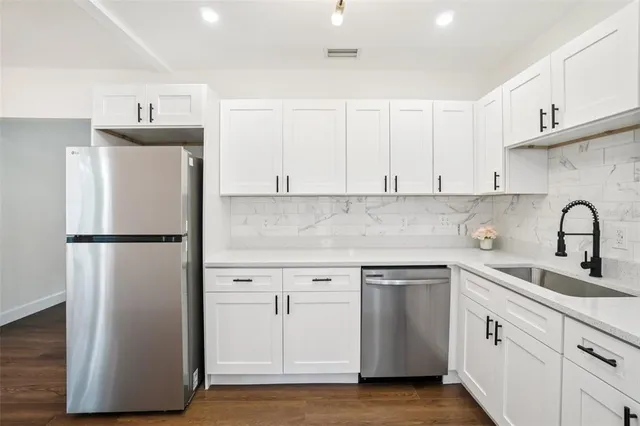 a kitchen with stainless steel appliances a refrigerator sink and microwave