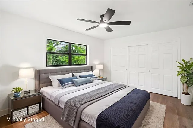 an empty room with wooden floor ceiling fan and windows