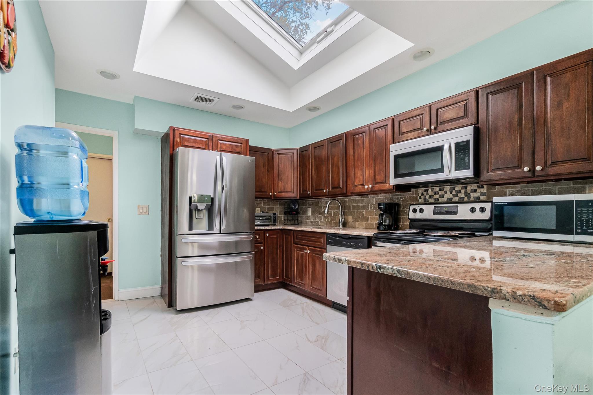 68 Riverdale Road Valley Stream, NY 11581 - Photo 4 of 19 a kitchen with stainless steel appliances granite countertop a refrigerator stove top oven a sink and dishwasher