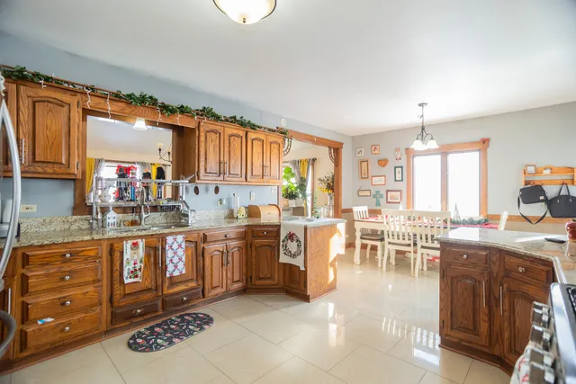 a kitchen with stainless steel appliances granite countertop a stove top oven a sink dishwasher and cabinets with wooden floor