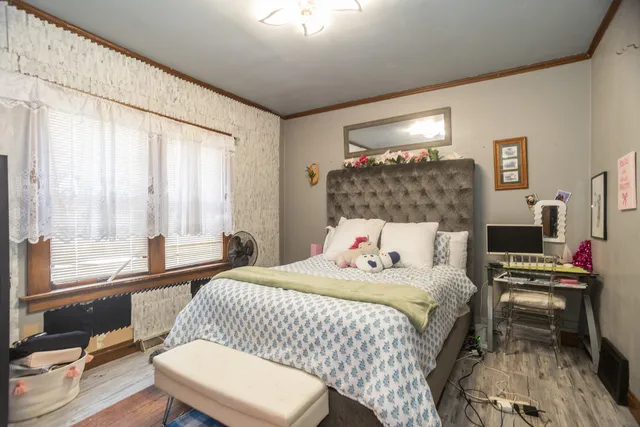 a bedroom with a bed table and a large window