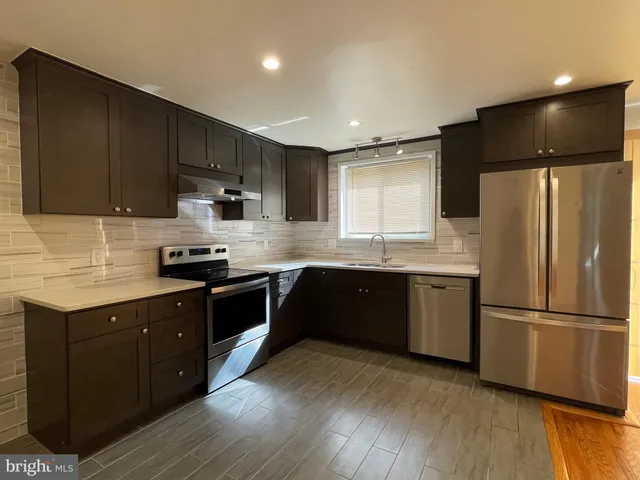 a kitchen with a refrigerator a sink and cabinets