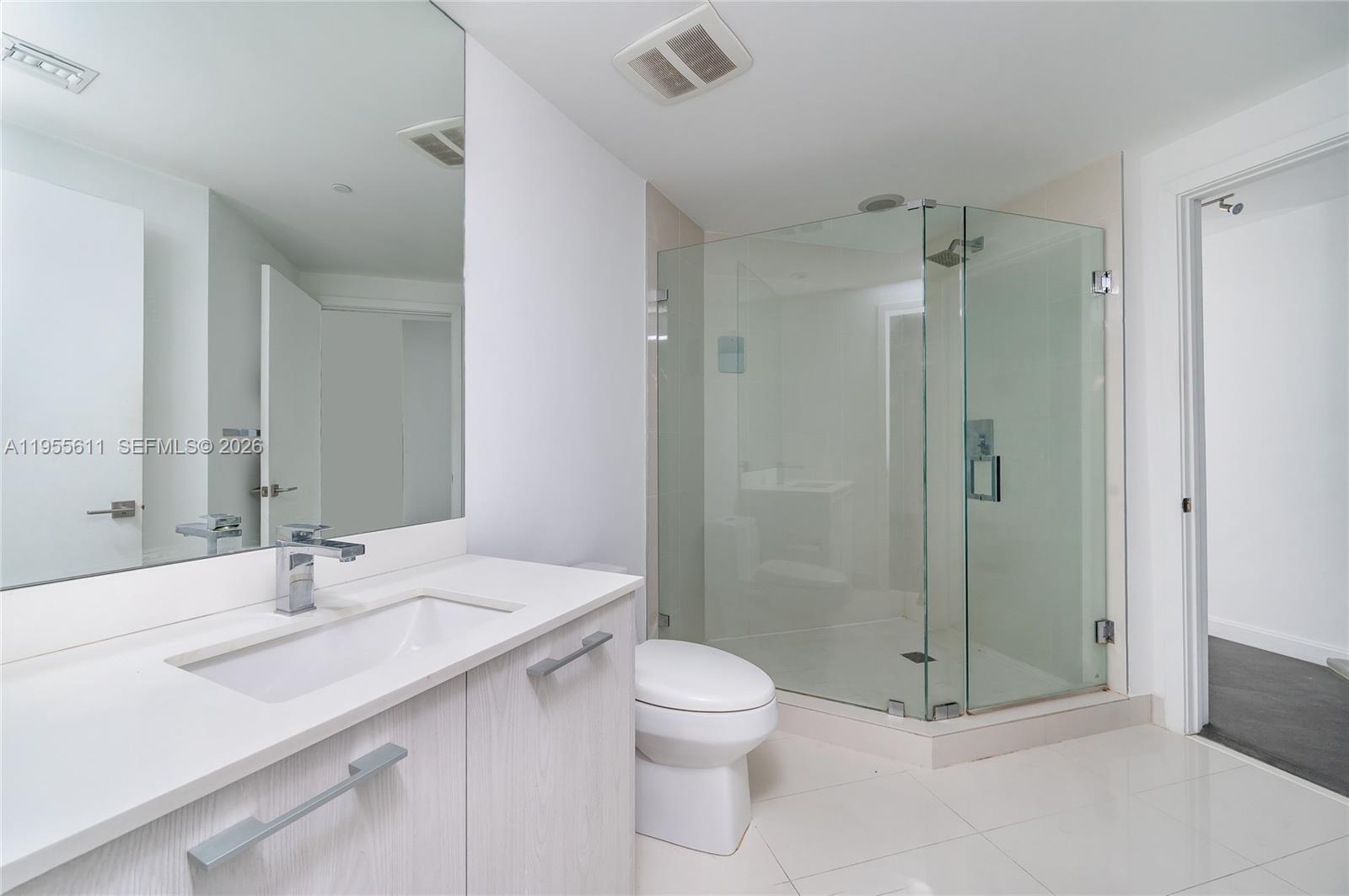 45 Southwest 9th Street, Unit 3401 Miami, FL 33130 - Photo 13 of 36 a bathroom with a shower sink vanity mirror and toilet