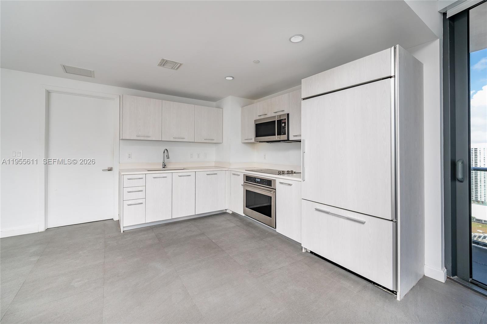 45 Southwest 9th Street, Unit 3401 Miami, FL 33130 - Photo 6 of 36 a kitchen with white cabinets and white appliances