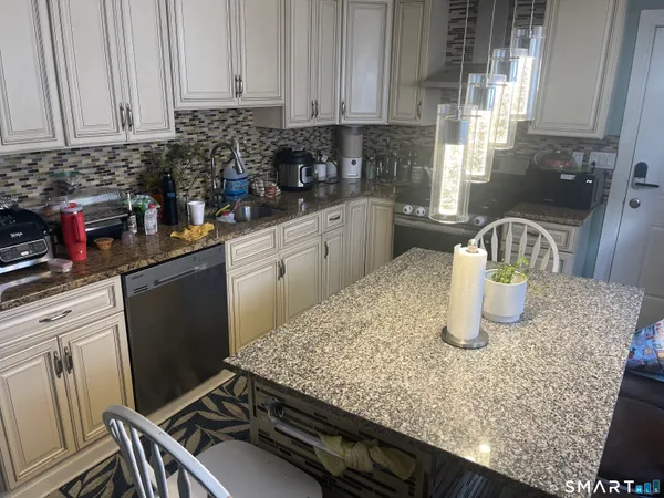 a kitchen with granite countertop a sink a stove and cabinets