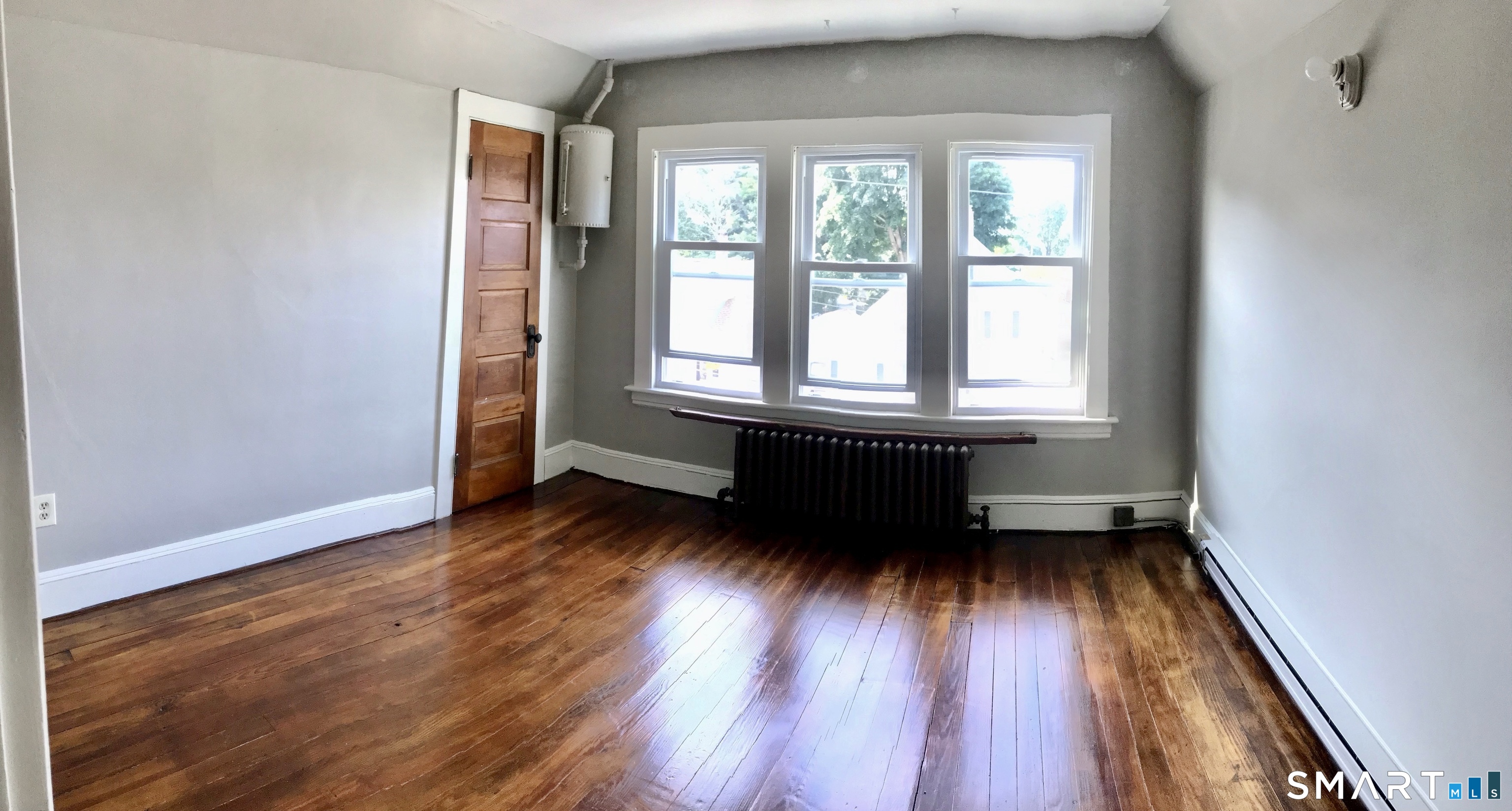52 Catherine Street Stratford, CT 06615 - Photo 12 of 19 an empty room with wooden floor and windows