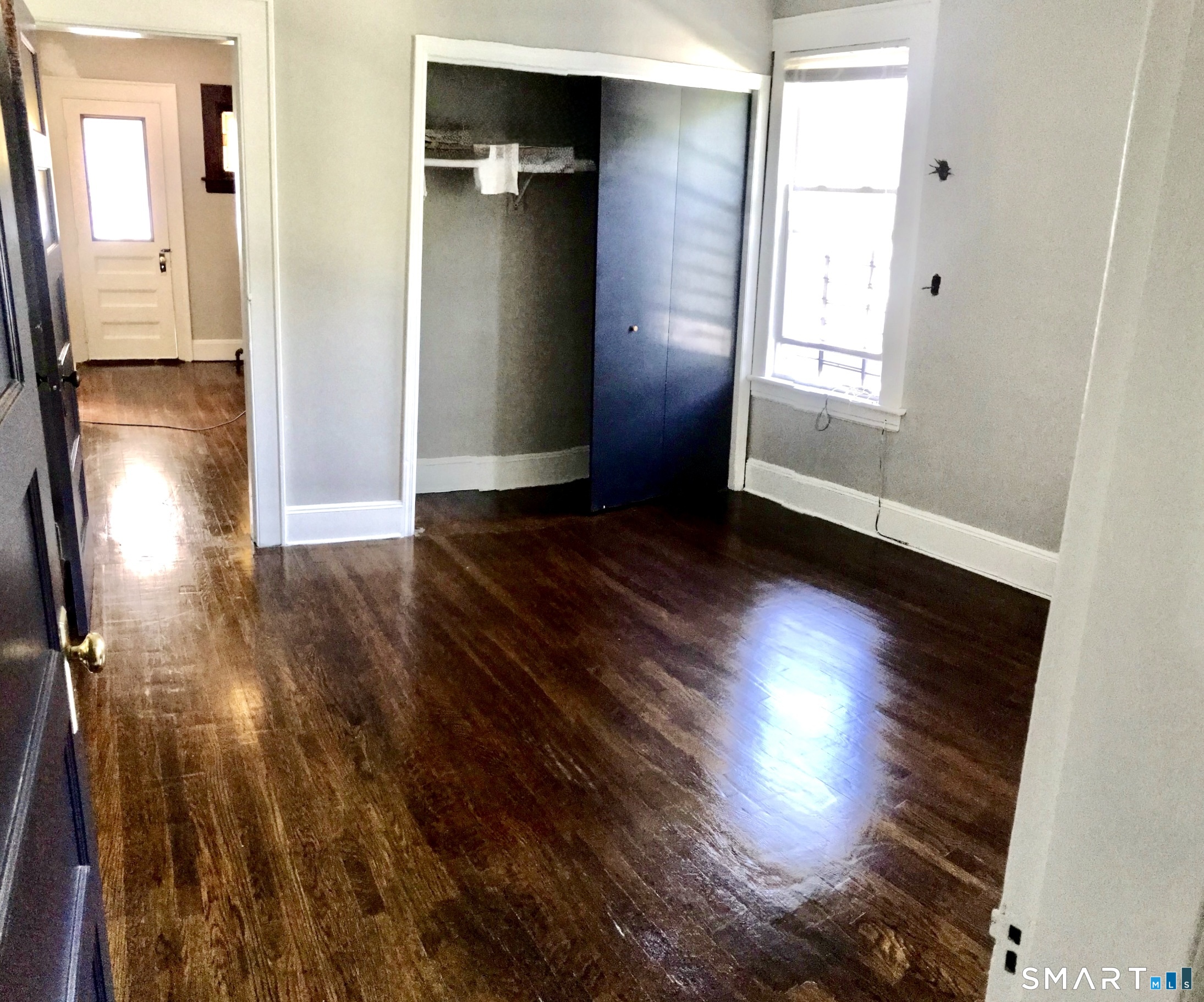 52 Catherine Street Stratford, CT 06615 - Photo 9 of 19 an empty room with wooden floor and windows