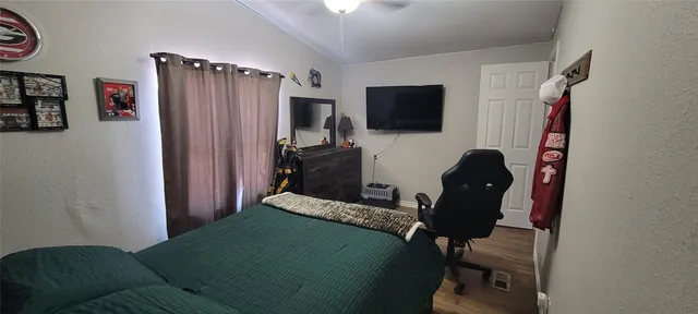 a bedroom with a bed and a television