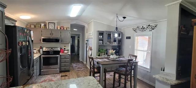 a kitchen with stainless steel appliances kitchen island granite countertop a refrigerator and a stove top oven