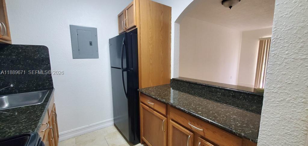 445 Southwest 11th Street, Unit 203 Miami, FL 33130 - Photo 13 of 18 a kitchen with granite countertop cabinets and refrigerator