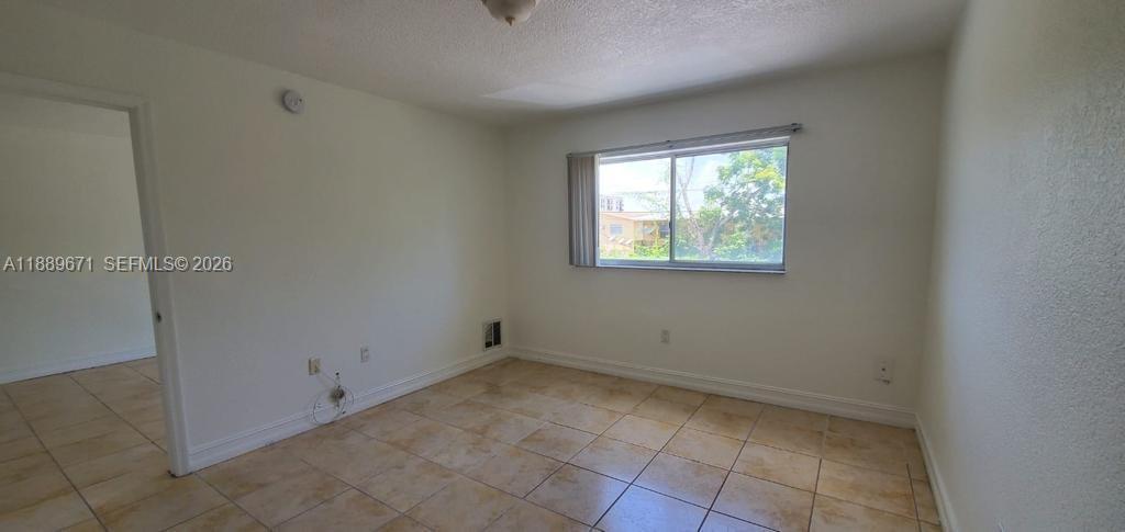445 Southwest 11th Street, Unit 203 Miami, FL 33130 - Photo 4 of 18 a view of an empty room with a window