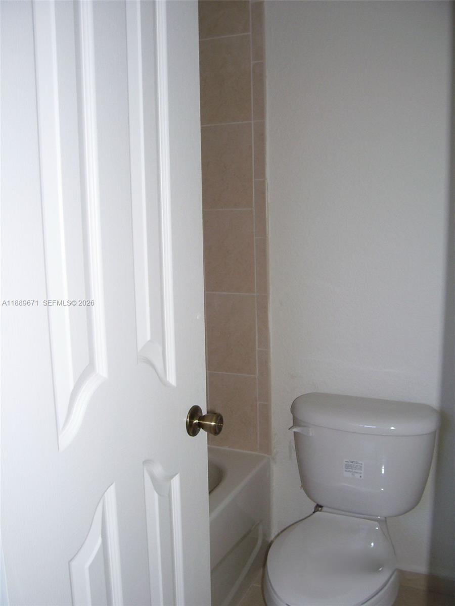 445 Southwest 11th Street, Unit 203 Miami, FL 33130 - Photo 6 of 18 a white toilet sitting next to a shower
