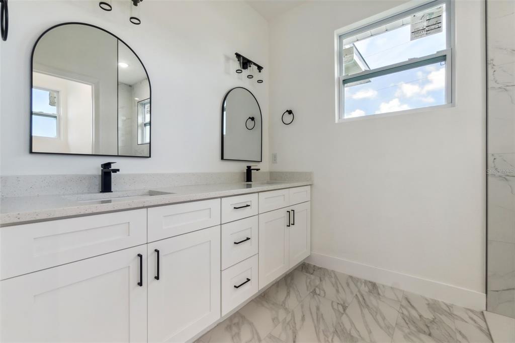 8 Cleat Court Placida, FL 33946 - Photo 16 of 24 a bathroom with a double vanity sink and mirror with window