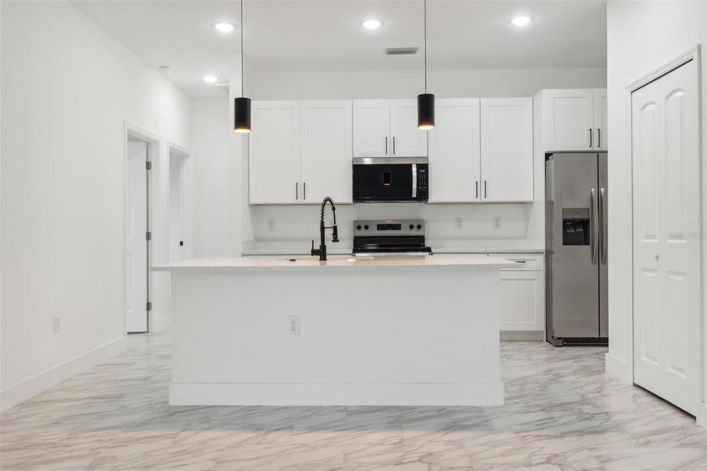 8 Cleat Court Placida, FL 33946 - Photo 10 of 24 a kitchen with kitchen island a white counter top space cabinets and stainless steel appliances