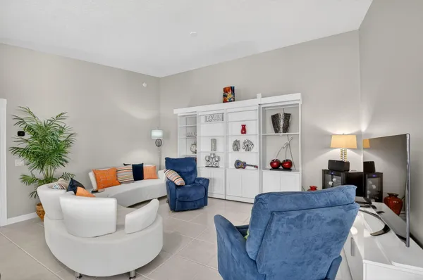 a dining room with furniture large windows and a chandelier